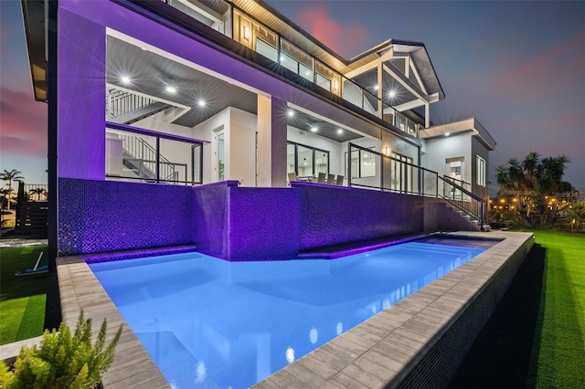 view of swimming pool featuring stairway and an infinity pool