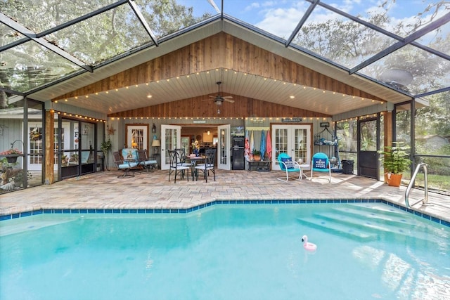 view of pool featuring french doors, ceiling fan, a patio, a lanai, and a mountain view