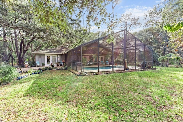 view of yard with glass enclosure and french doors