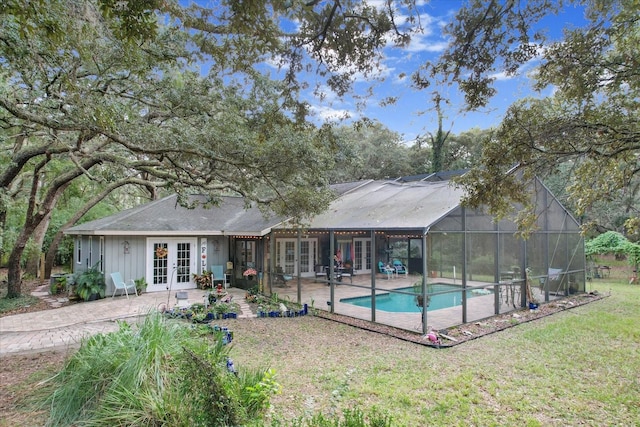 view of swimming pool with a lawn, a lanai, french doors, and a patio area