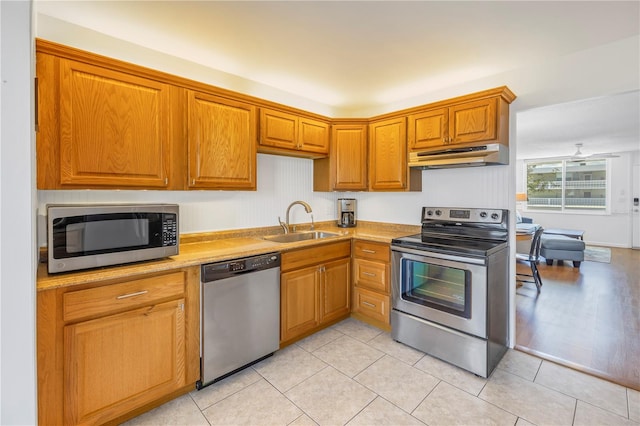 kitchen featuring appliances with stainless steel finishes, light tile patterned floors, and sink