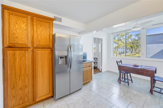 kitchen with ceiling fan, light tile patterned floors, and stainless steel refrigerator with ice dispenser