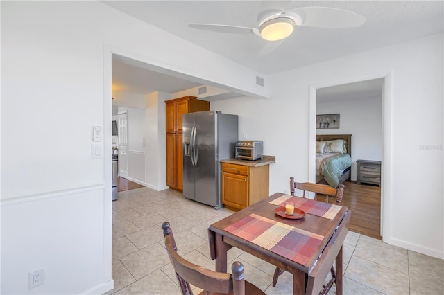 tiled dining space featuring ceiling fan