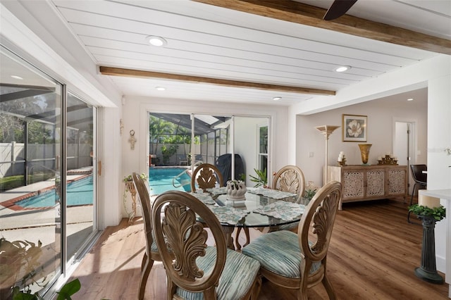 dining room with beamed ceiling, recessed lighting, a sunroom, and light wood-style floors