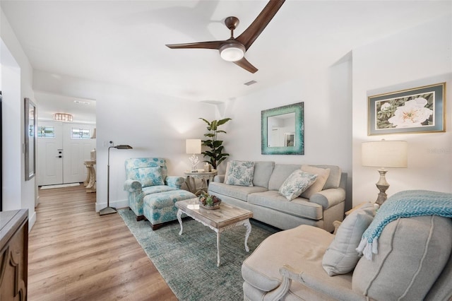 living area with light wood-style floors, ceiling fan, and visible vents