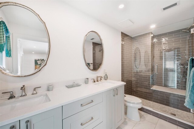 bathroom with a stall shower, visible vents, a sink, and toilet