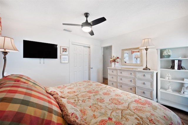 bedroom featuring ceiling fan, visible vents, a closet, and wood finished floors