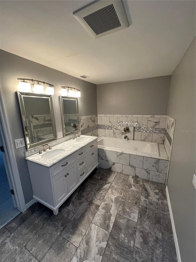 bathroom with vanity and tiled tub