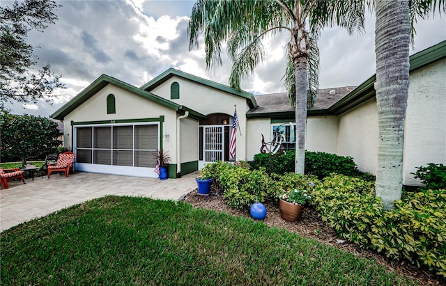 single story home with a garage and a front lawn