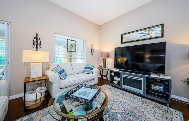 living room featuring dark wood-type flooring and ceiling fan