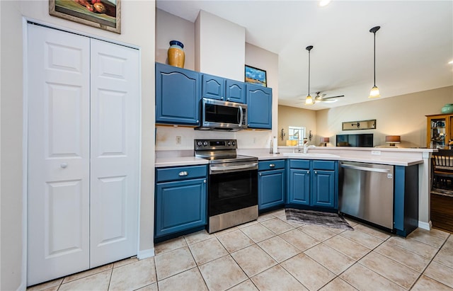 kitchen featuring stainless steel appliances, light tile patterned flooring, ceiling fan, decorative light fixtures, and blue cabinetry