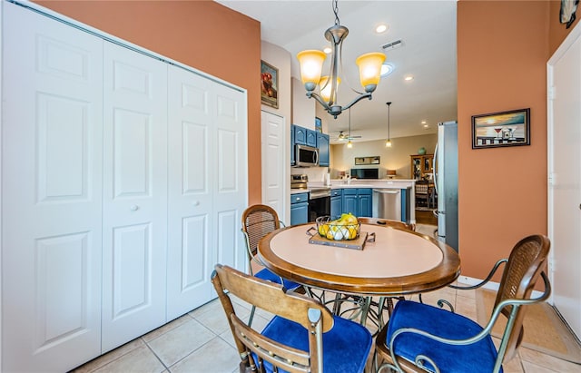 tiled dining room featuring ceiling fan with notable chandelier