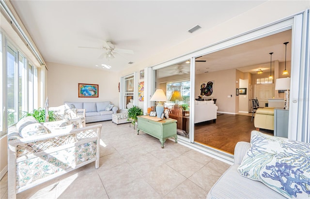 living room featuring plenty of natural light, ceiling fan, and light hardwood / wood-style flooring