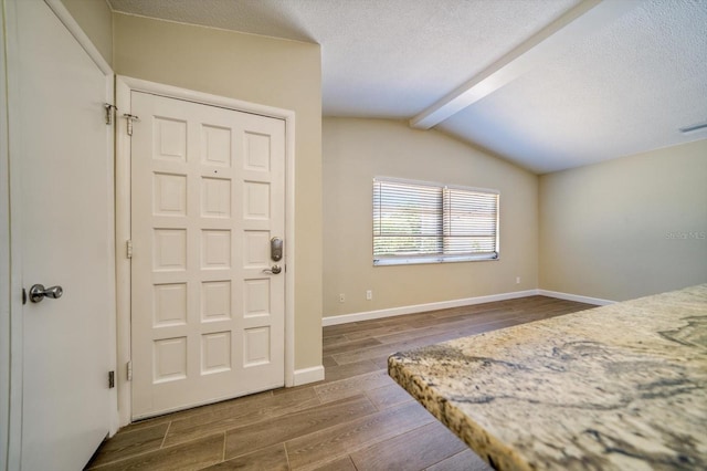 bedroom featuring hardwood / wood-style floors and vaulted ceiling with beams