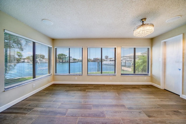 unfurnished sunroom featuring a water view