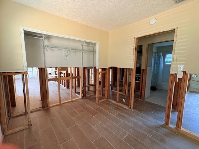 misc room with a textured ceiling and dark hardwood / wood-style flooring