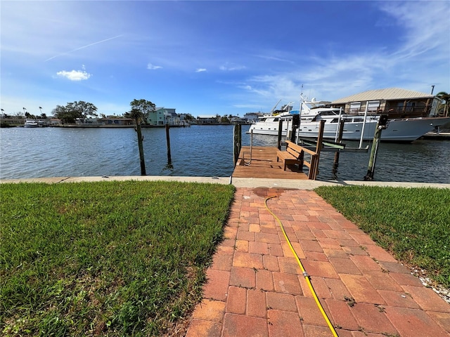 view of dock featuring a lawn and a water view