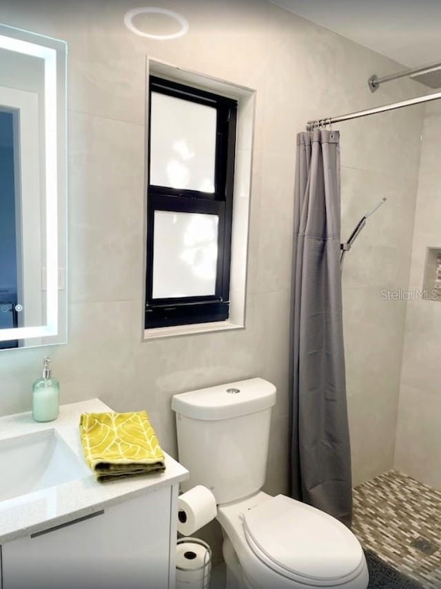 bathroom with toilet, vanity, and a shower with shower curtain