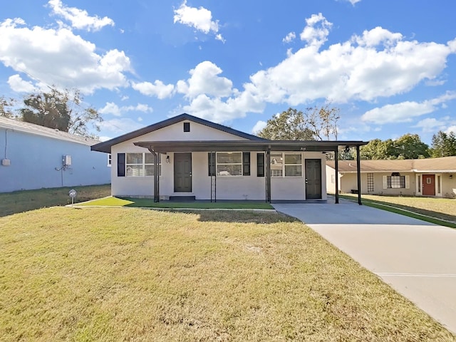 ranch-style house featuring covered porch, a front yard, and a carport