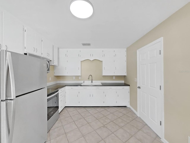 kitchen with white cabinetry, sink, light tile patterned floors, and appliances with stainless steel finishes