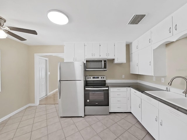 kitchen featuring stainless steel appliances, ceiling fan, sink, light tile patterned floors, and white cabinets