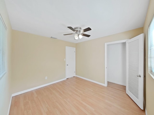 unfurnished bedroom with light wood-type flooring, a closet, and ceiling fan