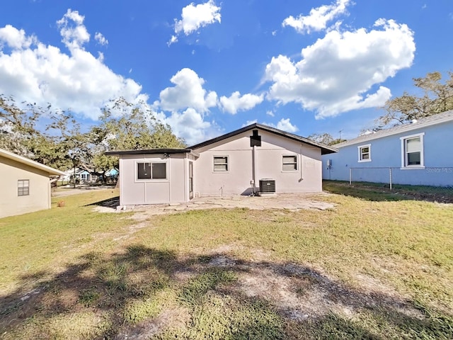 rear view of property with a yard and central air condition unit