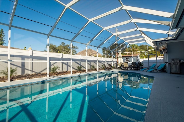 view of swimming pool with glass enclosure and a patio