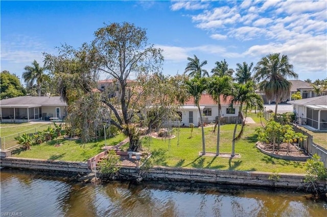 rear view of house with a lawn and a water view