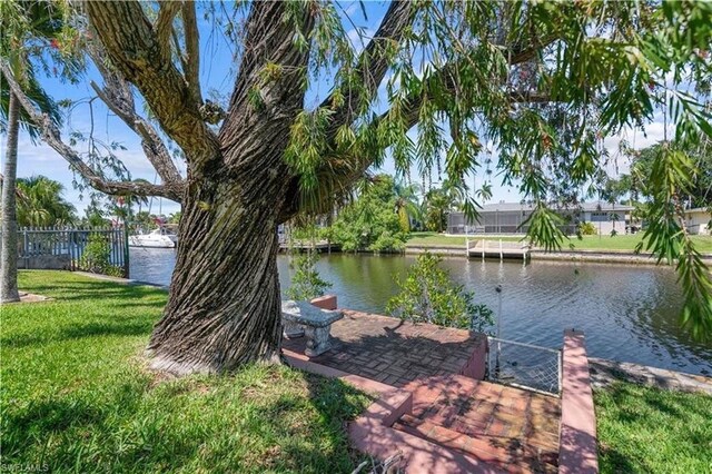 view of dock featuring a water view and a yard