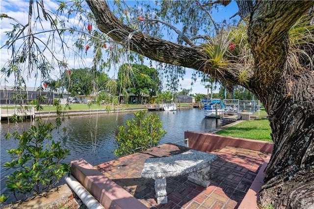 dock area with a water view and a lawn