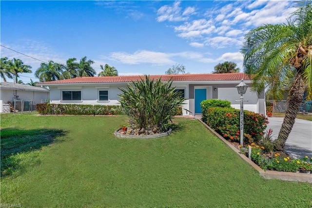 single story home featuring a garage and a front yard