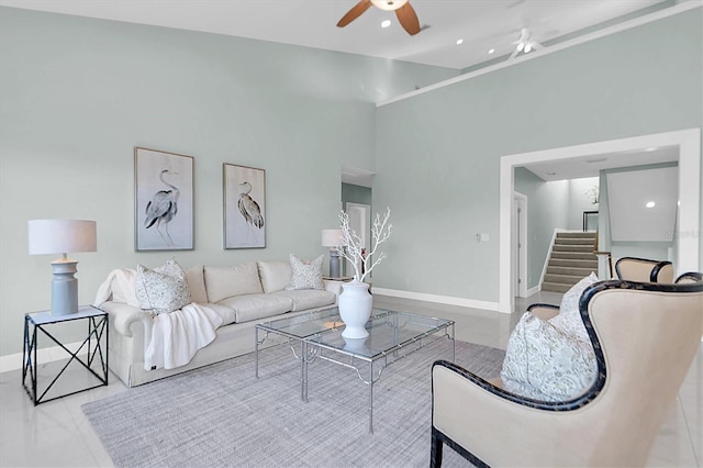 living room with ceiling fan and a high ceiling