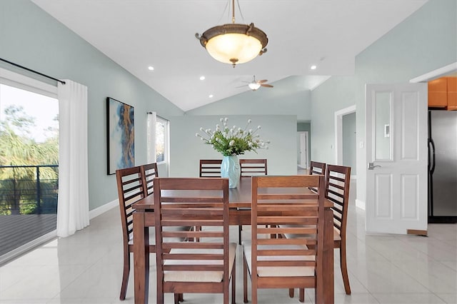 tiled dining space featuring ceiling fan and lofted ceiling