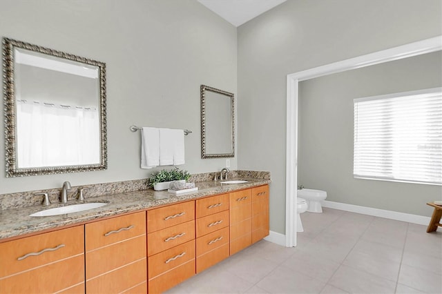 bathroom featuring tile patterned floors, vanity, toilet, and a bidet