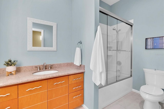 full bathroom featuring tile patterned floors, vanity, toilet, and bath / shower combo with glass door