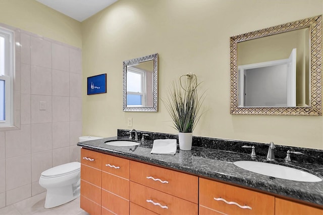 bathroom with vanity, toilet, tile walls, and a healthy amount of sunlight