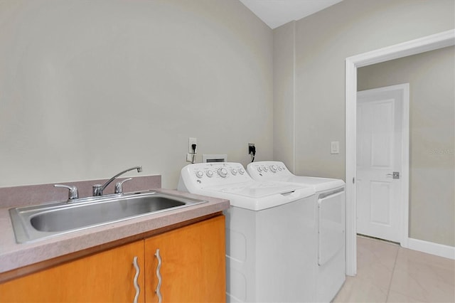 washroom with cabinets, independent washer and dryer, and sink