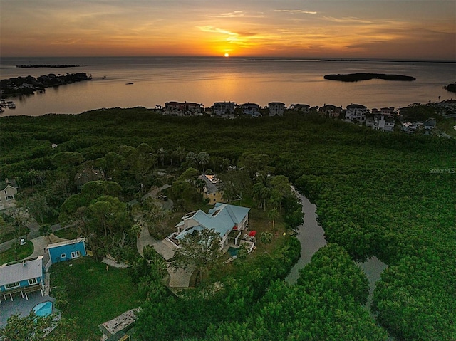 aerial view at dusk featuring a water view