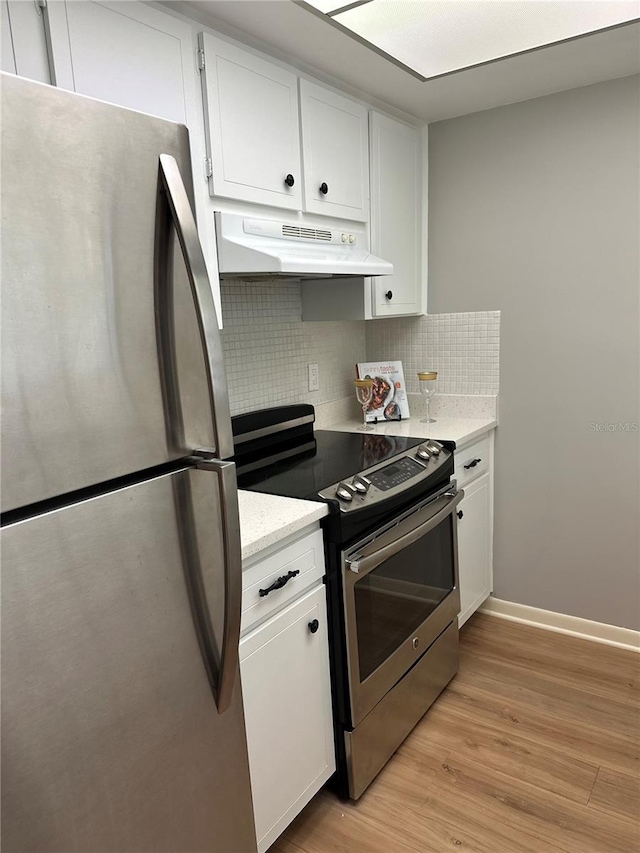 kitchen with light hardwood / wood-style flooring, backsplash, white cabinets, and stainless steel appliances