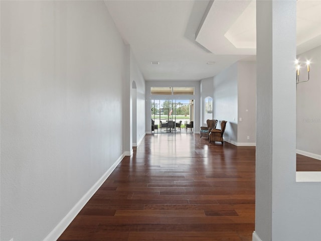 hall featuring dark hardwood / wood-style floors and a chandelier