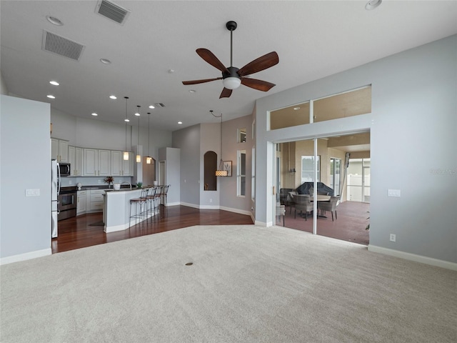 interior space featuring ceiling fan and dark carpet