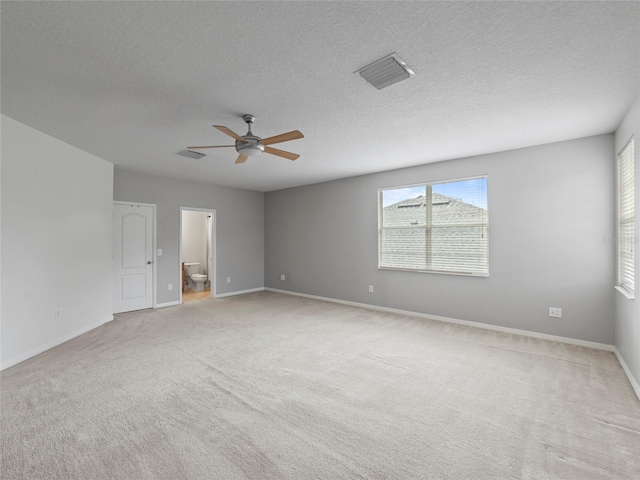 carpeted empty room with ceiling fan and a textured ceiling