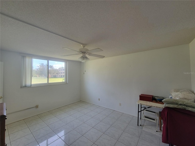 tiled spare room featuring a textured ceiling and ceiling fan