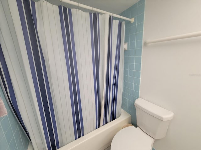 bathroom featuring shower / bath combination with curtain and toilet