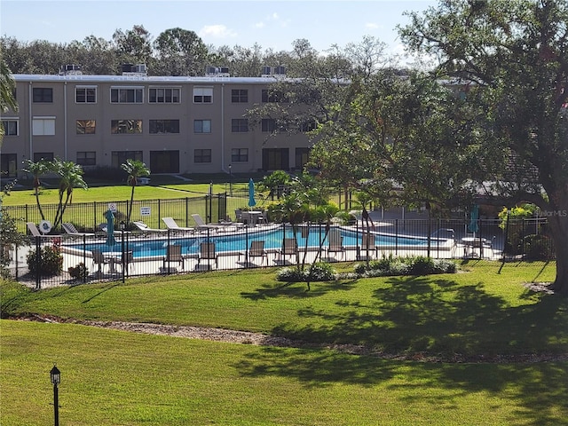 view of pool featuring a lawn