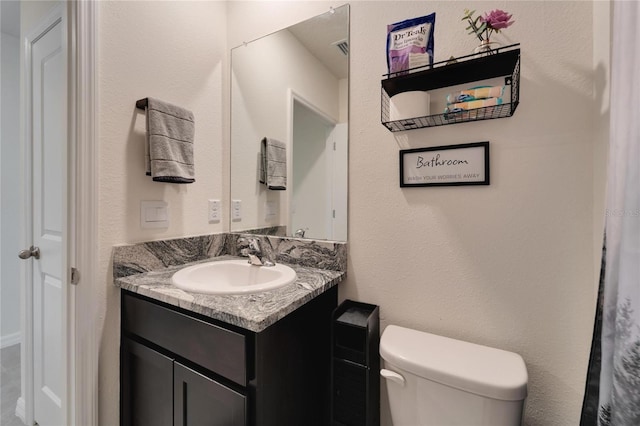 bathroom featuring vanity and toilet