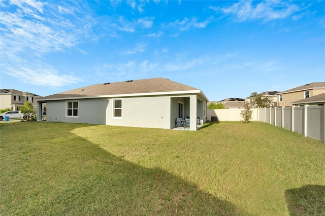 rear view of property with a patio area and a yard