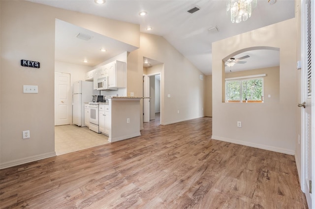 kitchen with white appliances, vaulted ceiling, ceiling fan, white cabinets, and light hardwood / wood-style floors