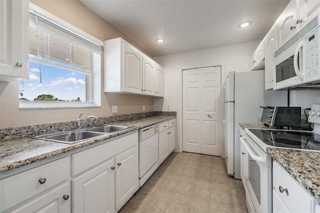 kitchen with light stone countertops, sink, white cabinets, and white appliances